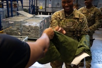 Airman reaches hand out to accept equipment issue.