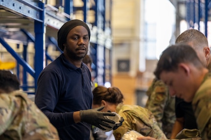 DOD civilian issues equipment to Airmen.