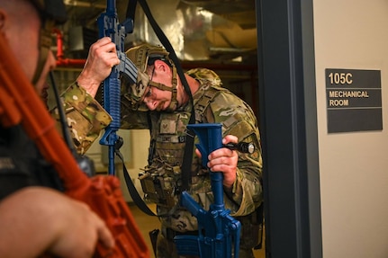 Airman removes rifle sling overhead.