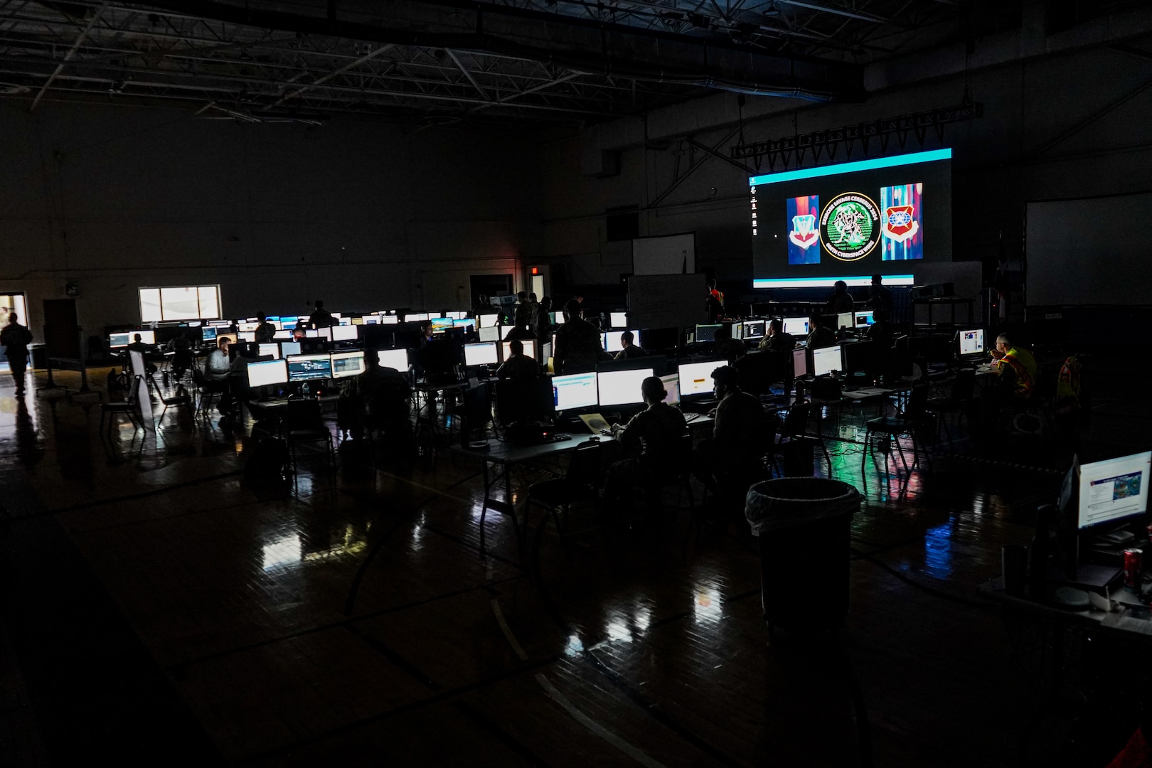 Airmen working on computers in a dark room