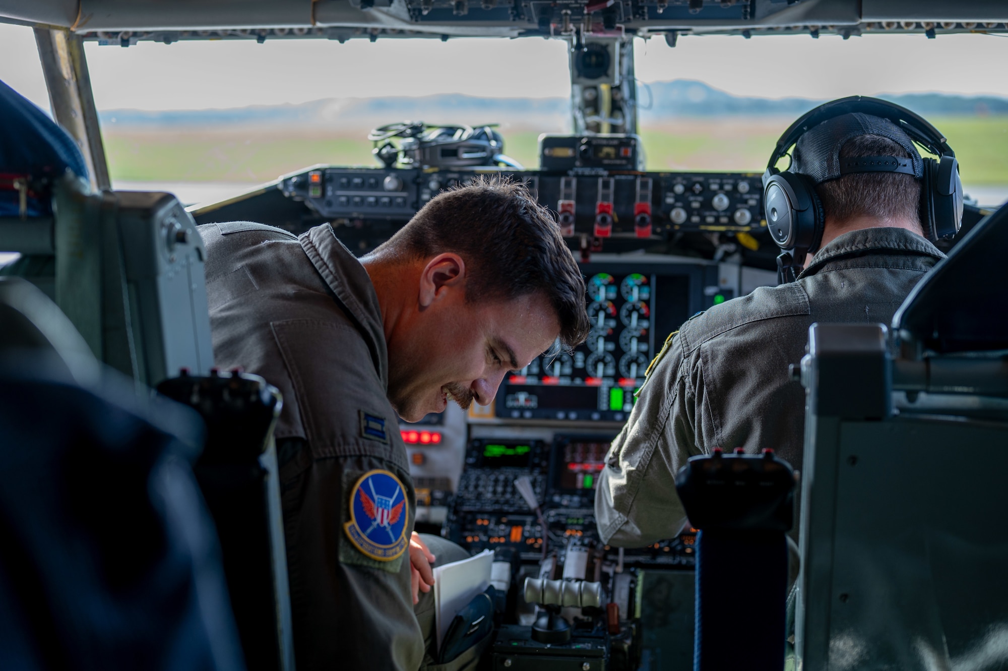 two pilots sit in a cockpit preparing for take off