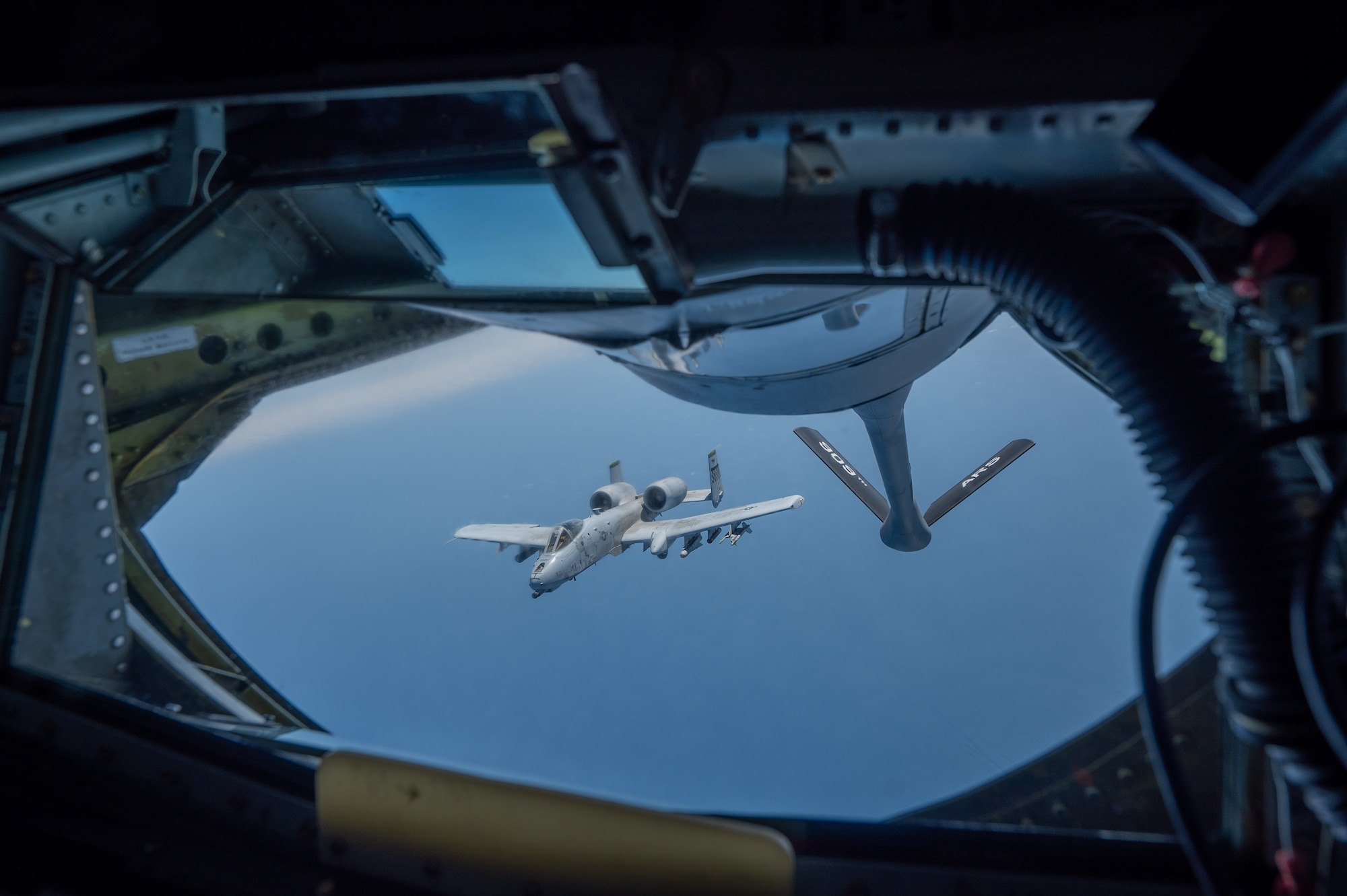 an A-10 aircraft flies away from another aircraft after being refueled, view from inside the boom pod