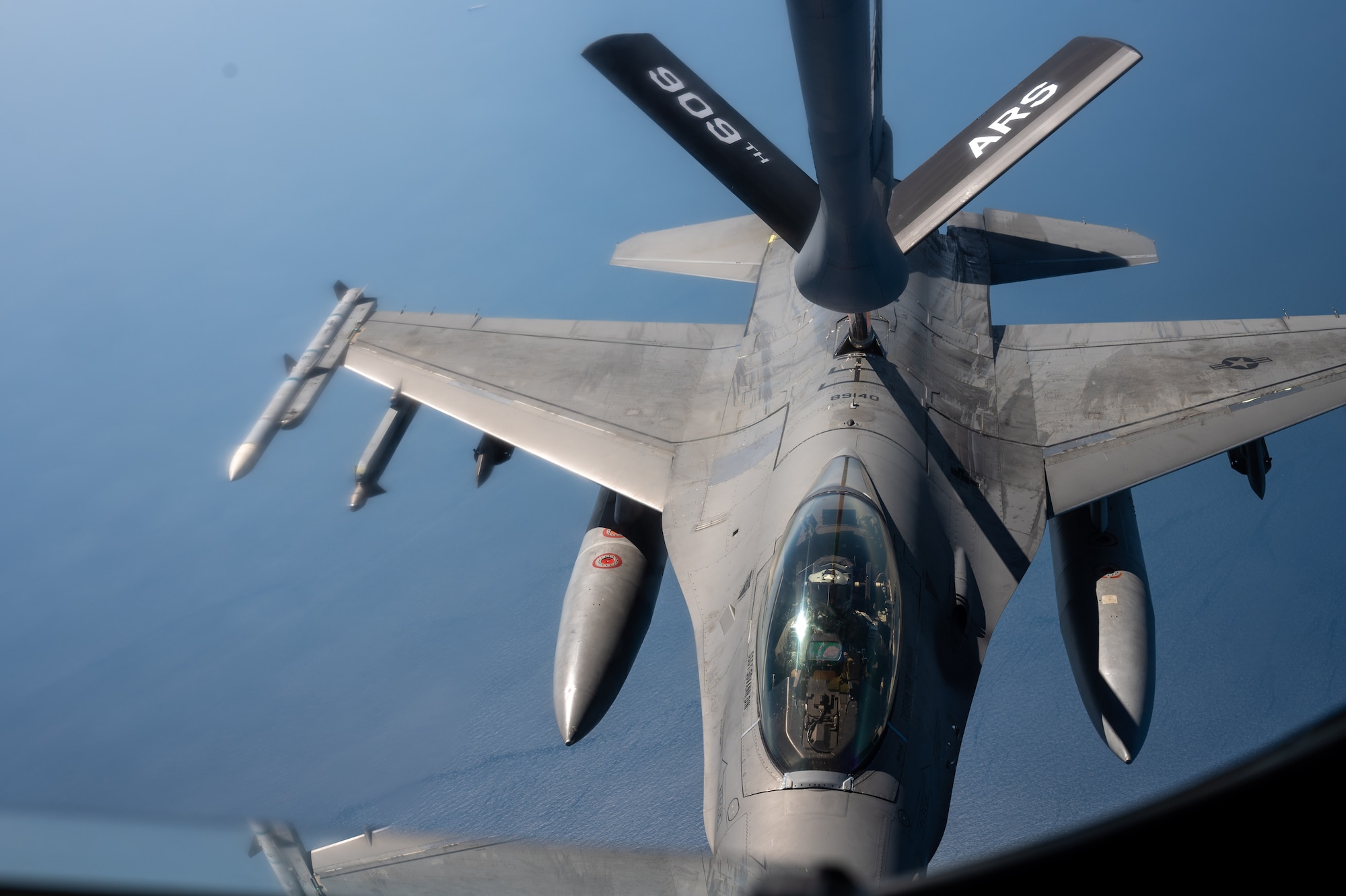 a F-16 aircraft gets refueled by another aircraft, view from inside the boom pod