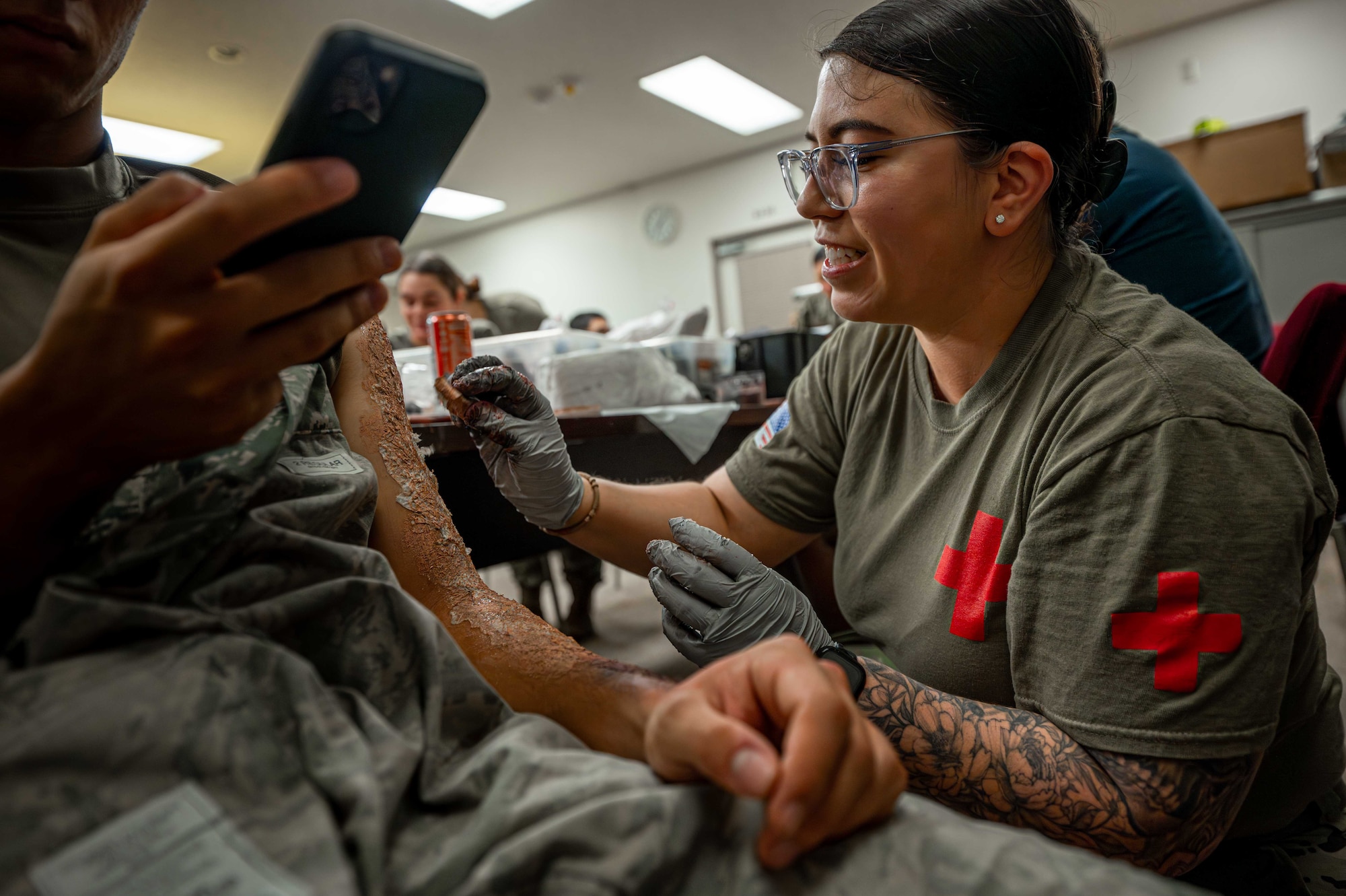 U.S. Air Force Staff Sgt. Sarah Jacinto, 18th Medical Group diagnostic imaging noncommissioned officer in charge, applies moulage to a volunteer for a simulated mass casualty exercise at Kadena Air Base, Japan, May 8, 2025.