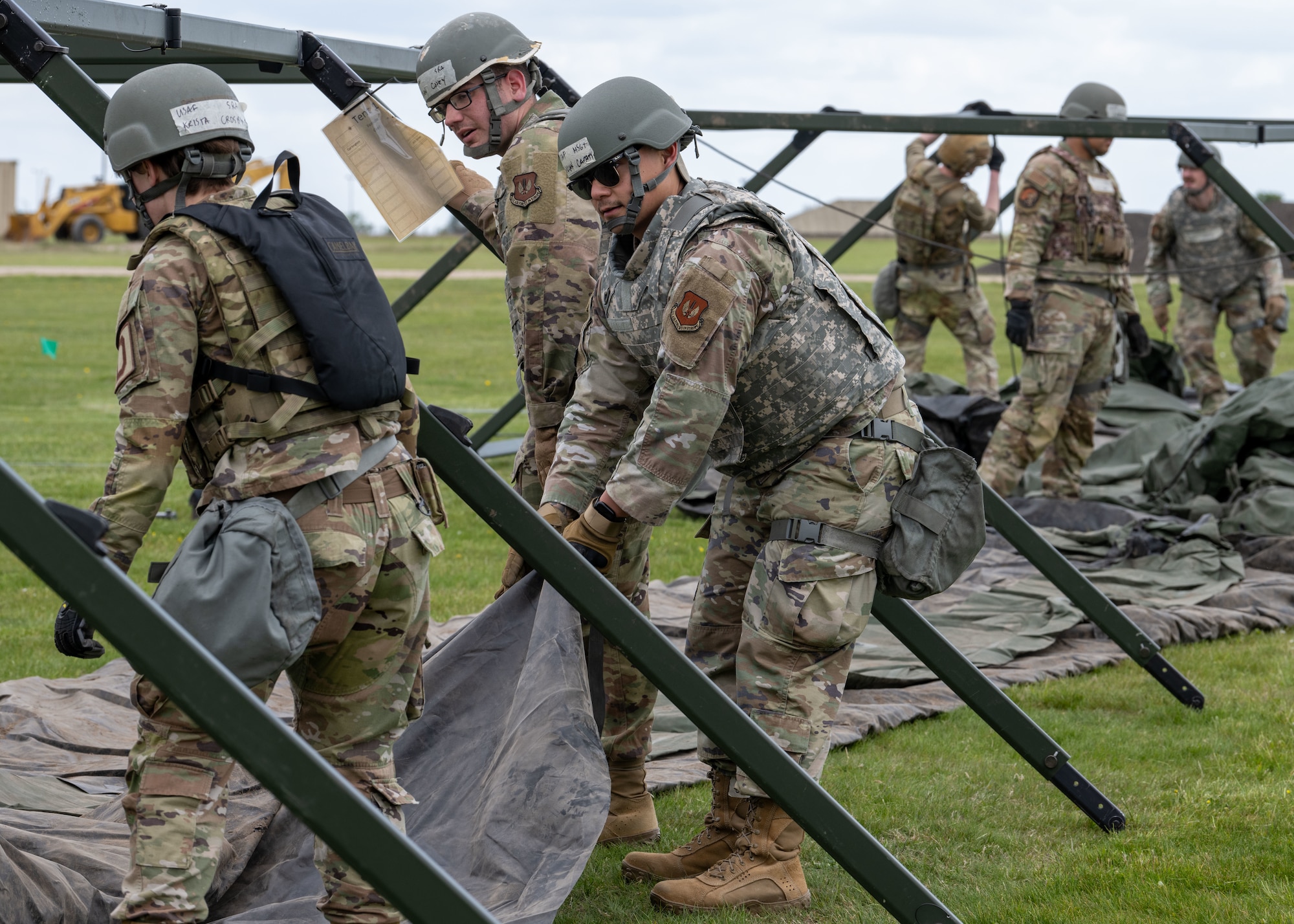 U.S. Airmen assigned to the 100th Civil Engineer Squadron work together to build temporary tents during combat readiness inspection Skyway Chariot at RAF Feltwell, England, May 8, 2025.