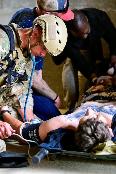 250404-N-BC658-1997 FORT BRAGG, NC (Apr. 04, 2025) A special operations medic of the U.S. Army John F. Kennedy Special Warfare Center and School's; Joint Special Operations Medical Training Center (JSOMTC) treats a simulated patient during a mass casualty event demonstration during the CAPEX2025 exercise on Fort Bragg, North Carolina, April 4, 2025. JSOMTC provides world-class medical and skills training to special operations medical personnel of the Army, Navy and Marine Corps. (U.S. Navy photo by Mass Communication Specialist 1st Class Russell Lindsey SW/AW)