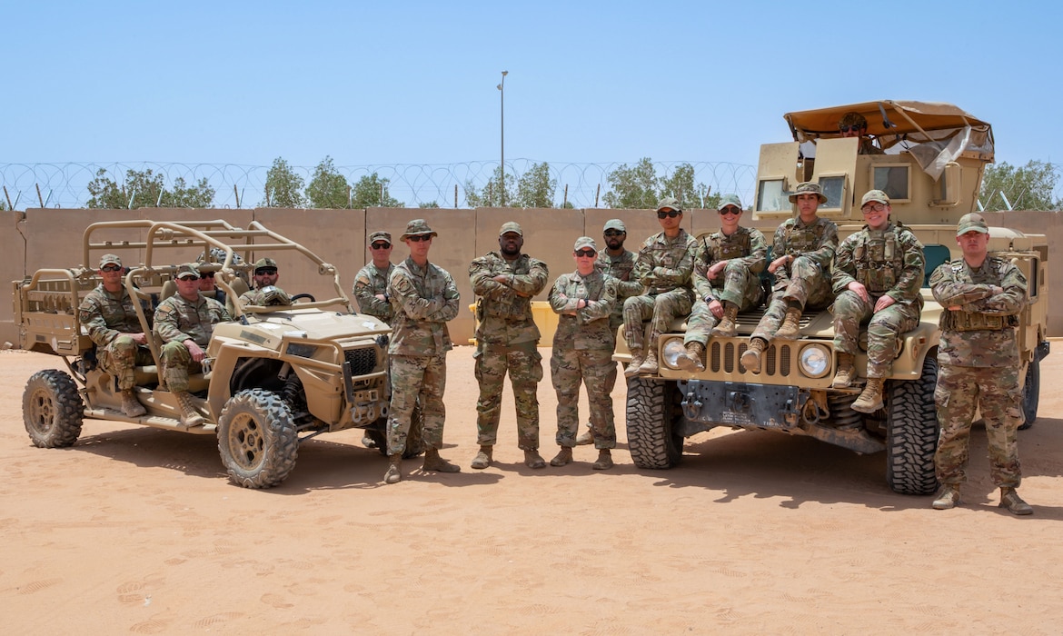 Members of Security Forces pose on top of and beside vehicles
