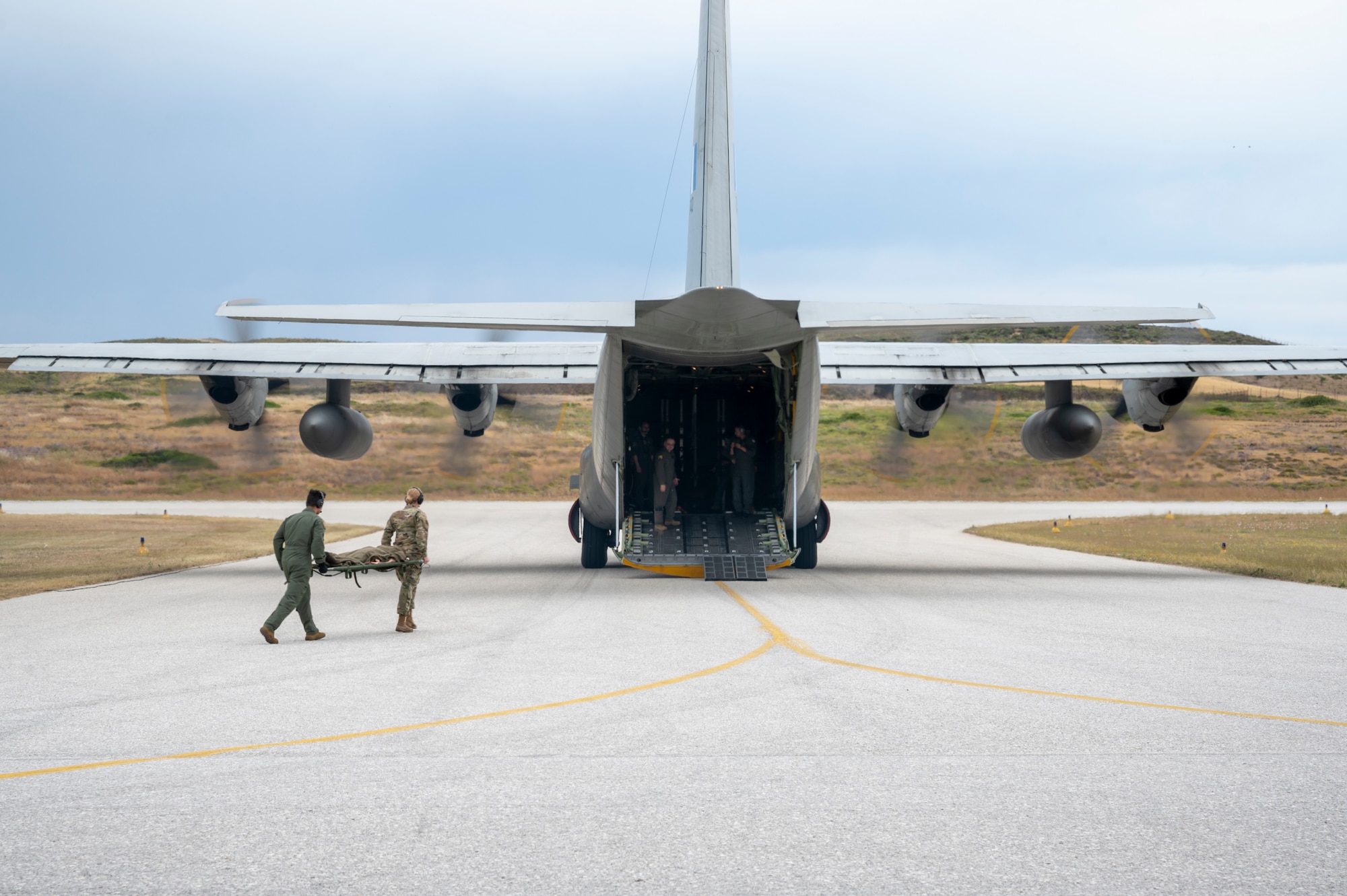 U.S. Air Force Staff Sgt. Charles Sanchez, 86th Aeromedical Evacuation Squadron mission clinical coordinator, and 1st Lt. Lauren Klima, 86th Logistics Readiness Squadron logistics readiness officer, carry a litter onto a Hellenic Air Force C-130H Hercules, at Skiros, Greece, during exercise Stolen Cerberus XII, May 5, 2025.
