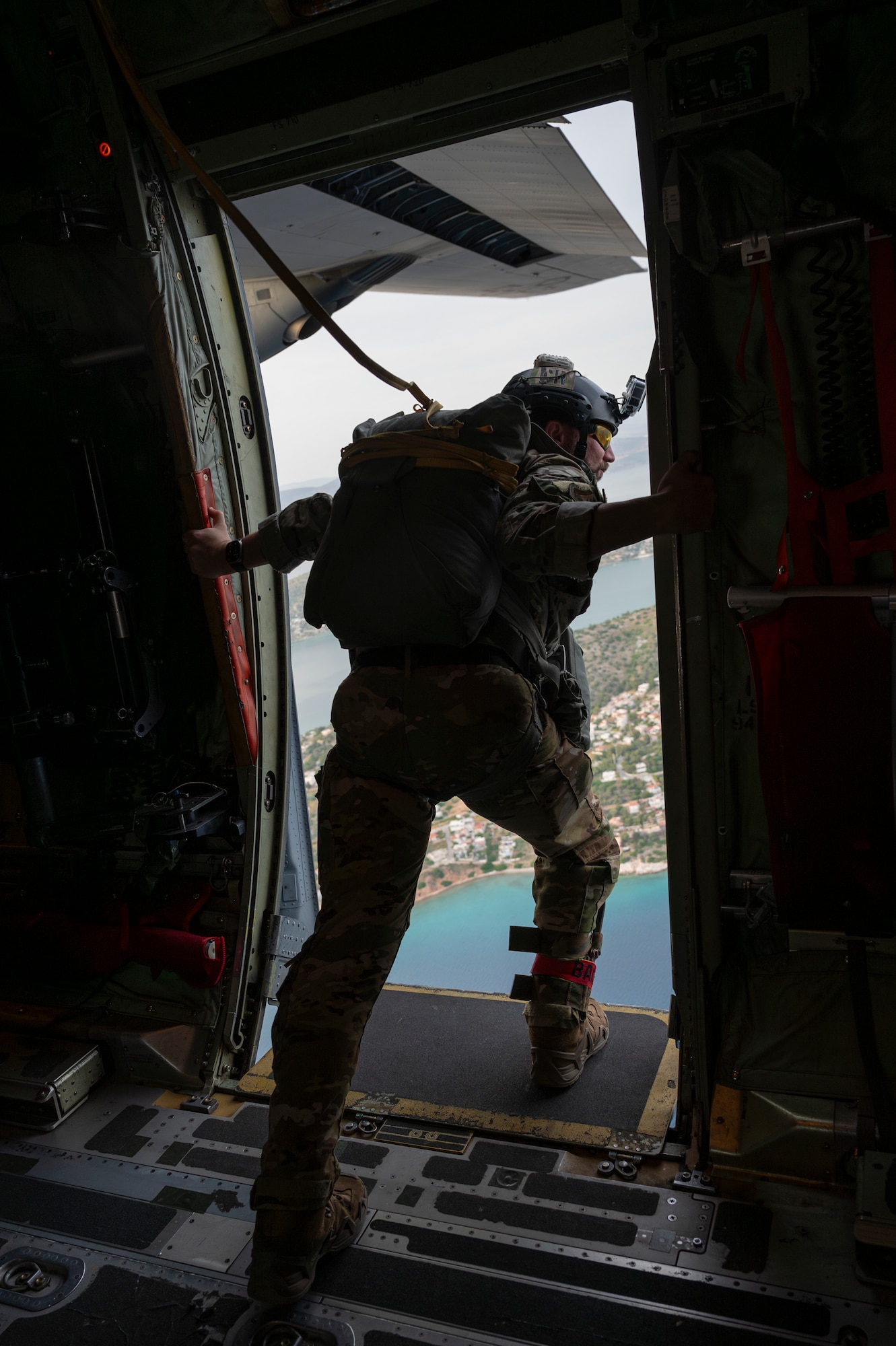 U.S. Air Force Master Sgt. Steve Baker, 435th Contingency Response Group jumpmaster, looks out of a U.S. Air Force C-130J Super Hercules near the Megara Drop Zone Air Base, Greece, May 6, 2025, during exercise Stolen Cerberus XII.