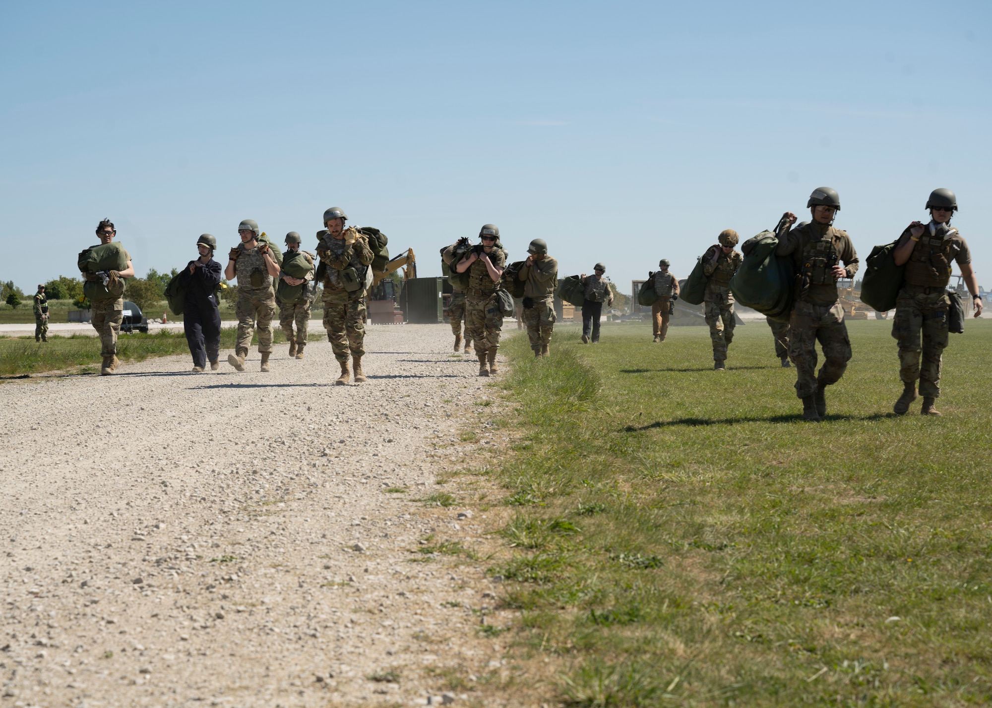 U.S. Airmen assigned to the 100th Civil Engineer Squadron move in unison toward a hardened shelter during combat readiness inspection Skyway Chariot at RAF Feltwell, England, May 9, 2025.