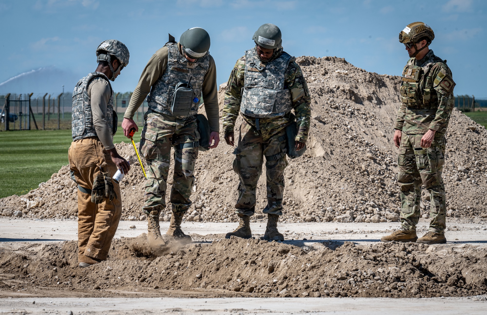U.S. Airmen assigned to the 100th Communications Squadron use tape measures and spray paint while making repairs to the damaged runway during combat readiness inspection Skyway Chariot at RAF Feltwell, England, May 9, 2025.