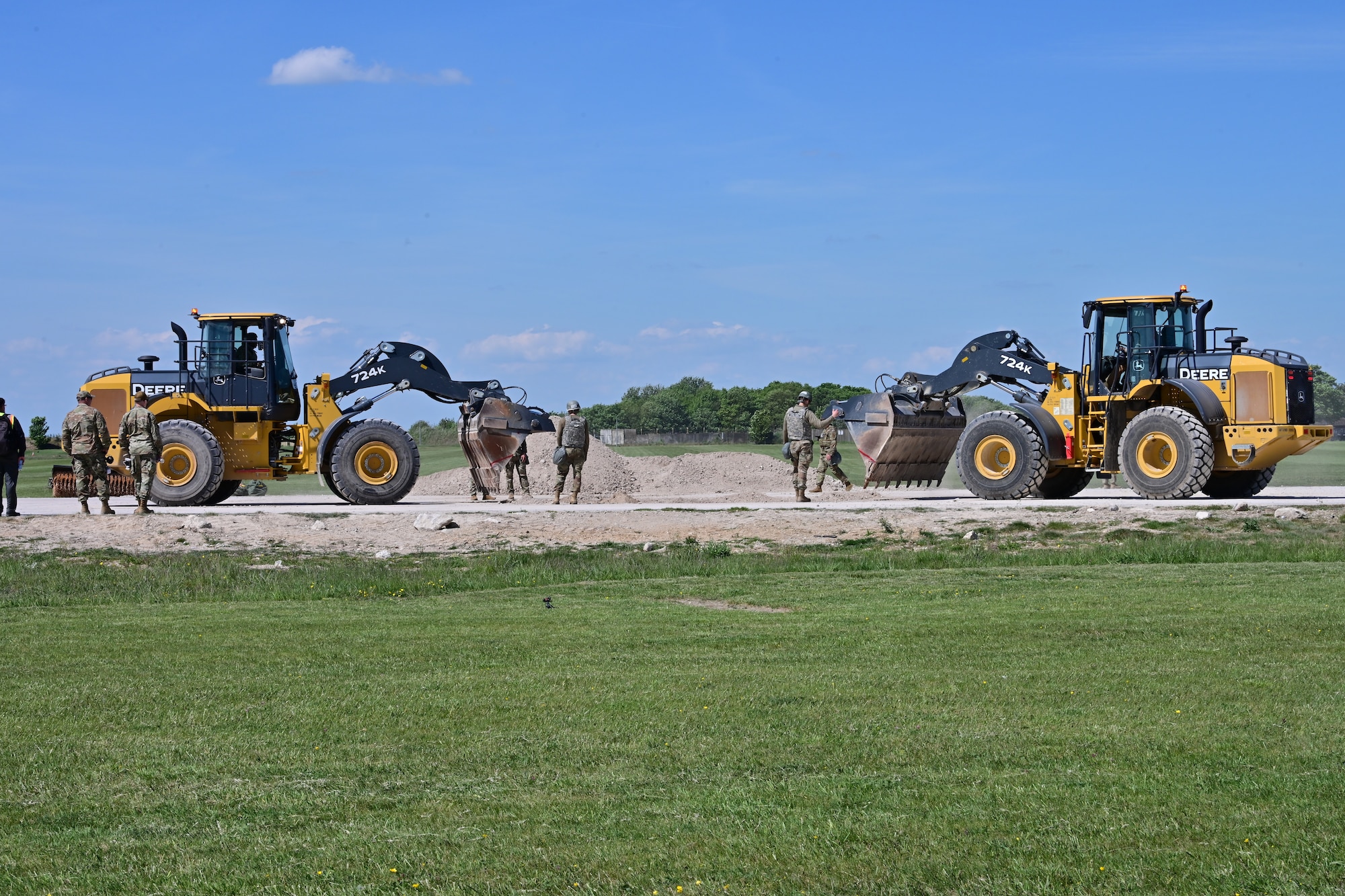U.S. Airmen assigned to the 100th Civil Engineer Squadron direct heavy machinery with the goal of clearing a crater of debris during combat readiness inspection Skyway Chariot at RAF Feltwell, England, May 9, 2025.