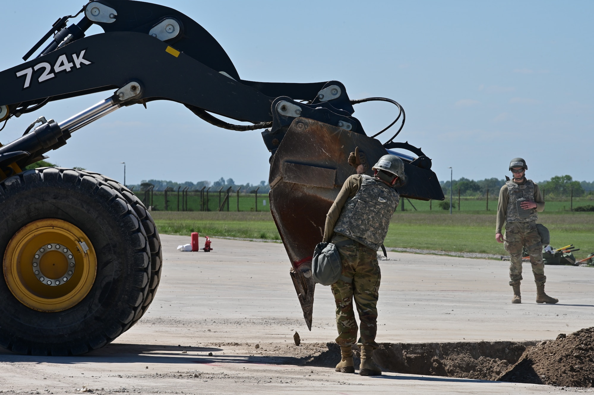 U.S. Airmen assigned to the 100th Civil Engineer Squadron direct heavy machinery to clear a crater of debris during combat readiness inspection Skyway Chariot at RAF Feltwell, England, May 9, 2025.