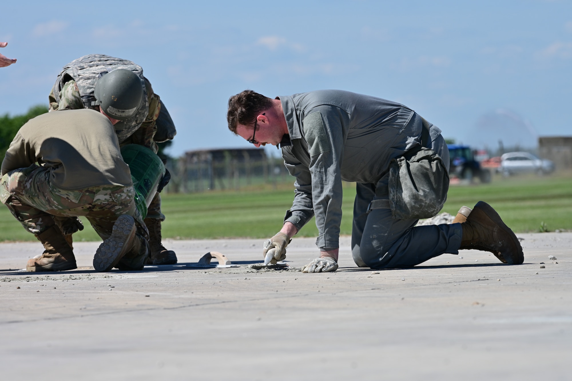 U.S. Air Force Senior Airman Cade Nut, 100th Civil Engineer Squadron heating, ventilation and air conditioning journeyman, fills holes in the runway with cement during combat readiness inspection Skyway Chariot at RAF Feltwell, England, May 9, 2025.
