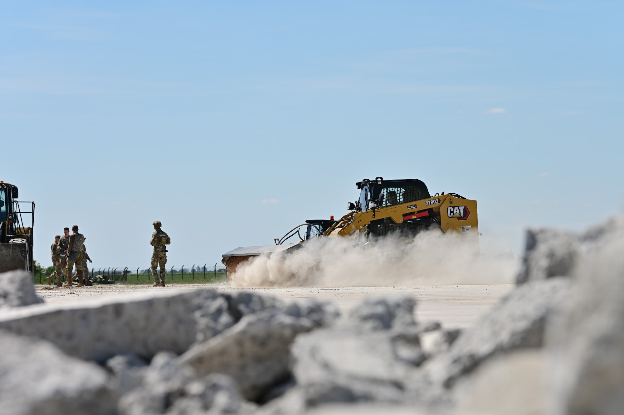A U.S. Airman assigned to the 100th Civil Engineer Squadron drives a bobcat skid steer to clear the flight line of debris during combat readiness inspection Skyway Chariot at RAF Feltwell, England, May 9, 2025.