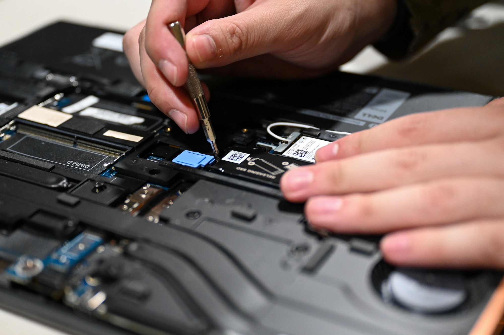U.S. Airmen opens a computer and removes components within