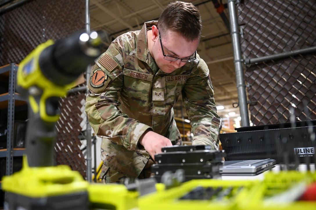 U.S. Airmen deconstructs a computer on a workbench