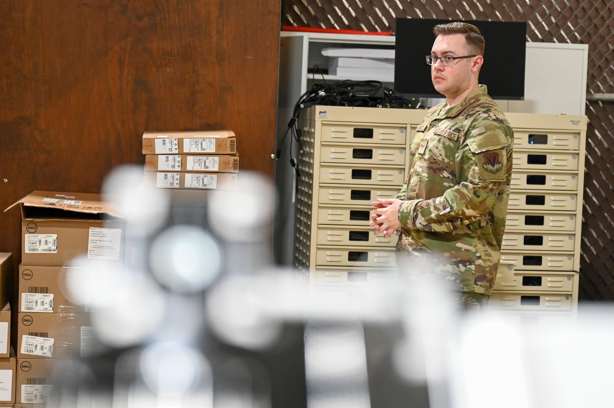 U.S. Airmen stands next to computer rack.