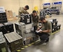 Radames Feliciano, right, a biomedical equipment technician with the U.S. Army Medical Materiel Agency, works with medics from 2nd Brigade, 82nd Airborne Division, to inventory medical equipment at the new Home-Station Medical Maintenance Support shop at Fort Liberty, North Carolina.