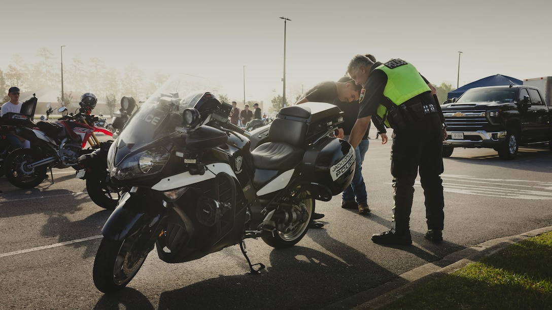 Retired U.S. Marine Corps Master Sgt. Michael Frazier, right, a traffic reconstructionist with the Jacksonville Police Department, speaks to U.S. Marines, Sailors and civilians across II Marine Expeditionary Force about motorcycle safety during the 2d Marine Division (MARDIV) poker run on Camp Lejeune, North Carolina, May 2, 2024. 2d MARDIV conducted a group ride to promote safe riding, camaraderie, and mentorship through a series of physical and mental skills stations across Marine Corps Base Camp Lejeune and Marine Corps Air Station New River to raise awareness for the upcoming motorcycle riding season. (U.S. Marine Corps photo by Pfc. Micah Thompson)