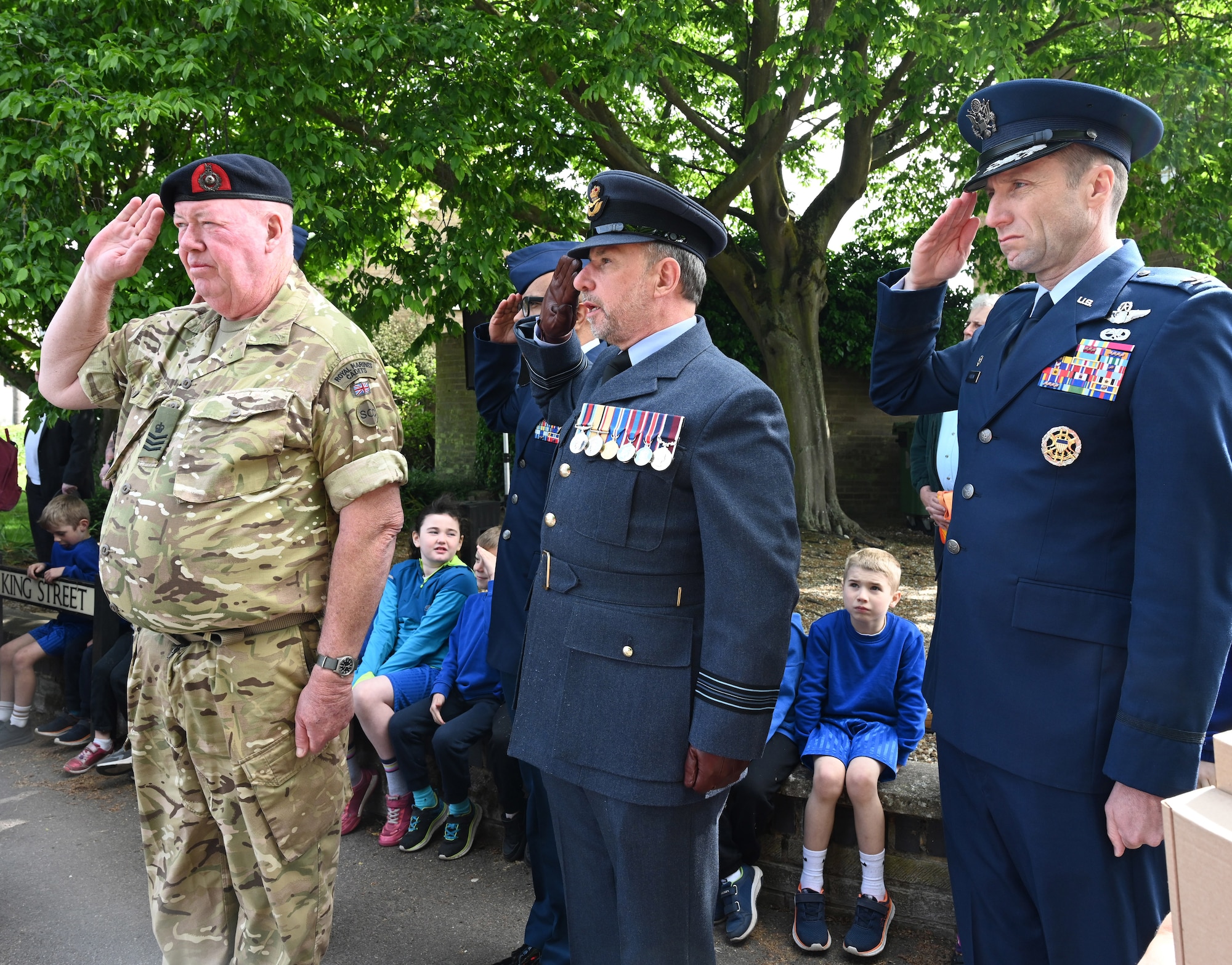 U.S. Air Force Col. Ryan Garlow, right, 100th Air Refueling Wing commander; RAF Squadron Leader  Andrew Bell, center, RAF Mildenhall station commander, and Royal Marines Cadets Colour Sgt. John Tillotson, Mildenhall and Newmarket Sea Cadets and Royal Marines Cadets, render salutes during the playing of “The Last Post” during a ceremony marking the 80th anniversary of Victory Day for World War II – commonly known as Victory in Europe Day – in Mildenhall, Suffolk, May 8, 2025. The Last Post is traditionally played to mark the historic moment peace was secured and victory was declared across Europe. Team Mildenhall Airmen participated in eight events in the local community. (U.S. Air Force photo by Karen Abeyasekere)