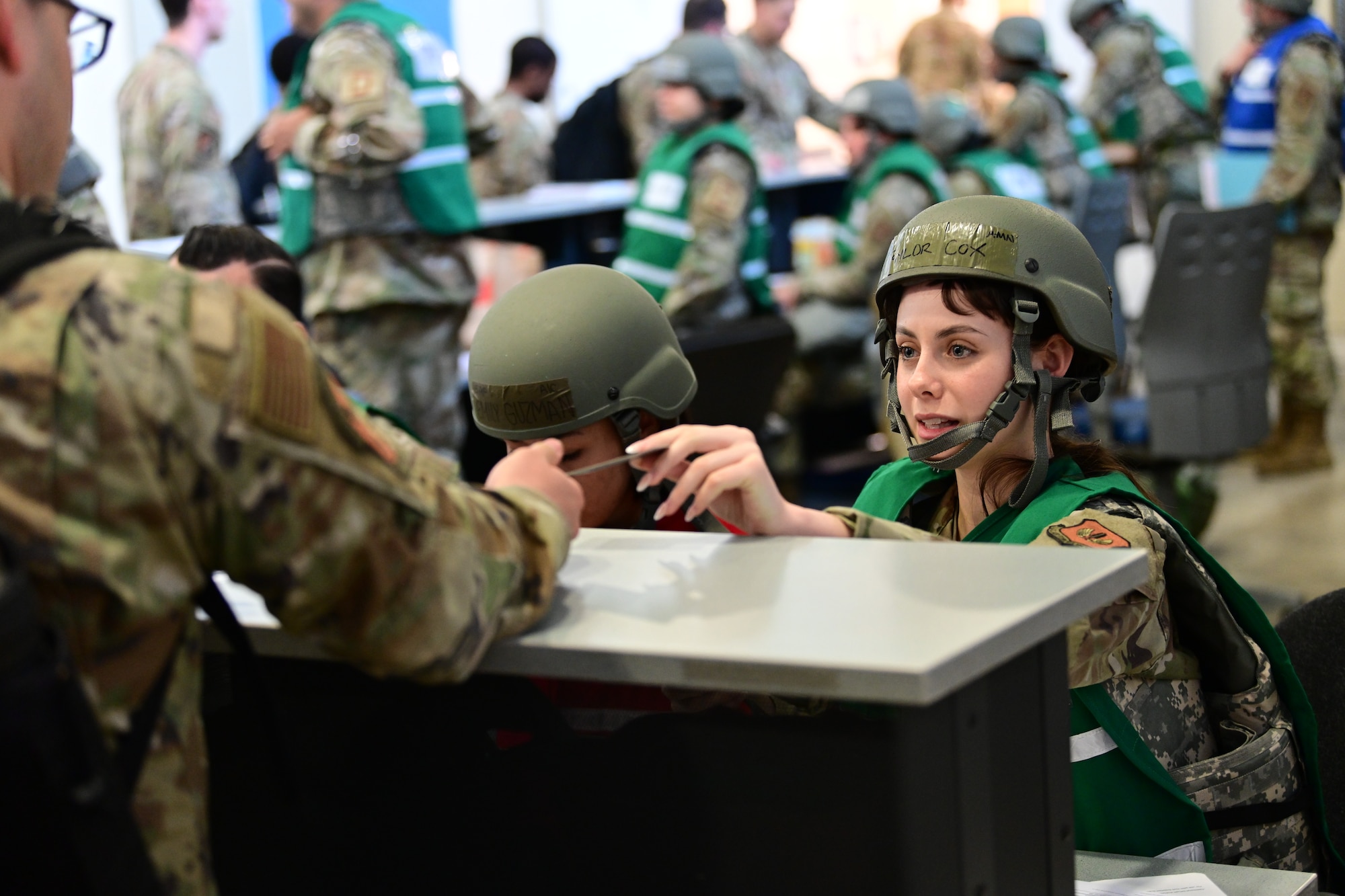 U.S. Air Force Airman Taylor Cox, 100th Force Support Squadron services technician, helps an Airman in the deployment line during combat readiness inspection Skyway Chariot at RAF Mildenhall, England, May 8, 2025.