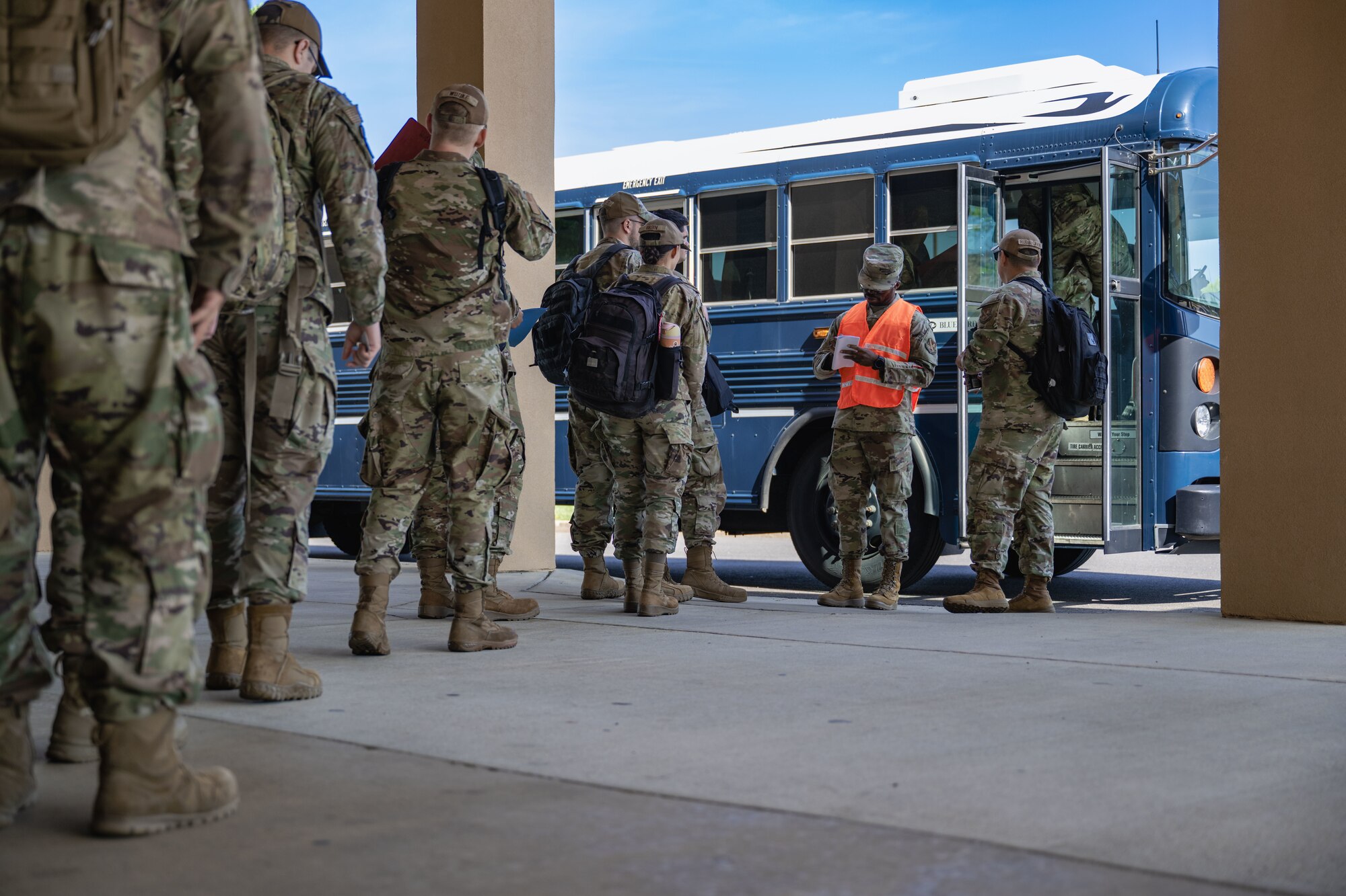 Airmen board a bus to go to a personnel deployment function line during a Combat Readiness Inspection.