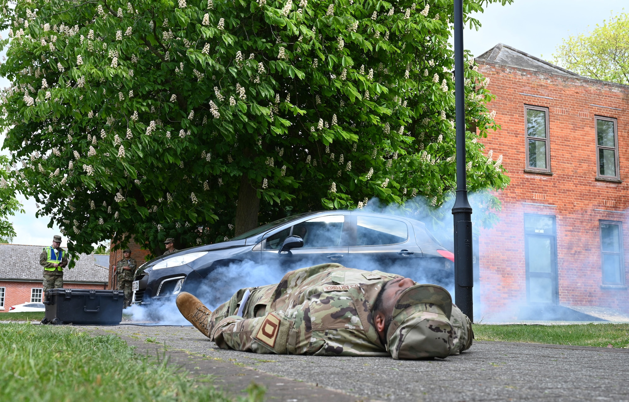 A U.S. Airman from the 100th Comptroller Squadron role plays as a casualty during a simulated vehicle-borne improvised explosive device scene during the combat readiness inspection Skyway Chariot at RAF Mildenhall, England, May 8, 2025.