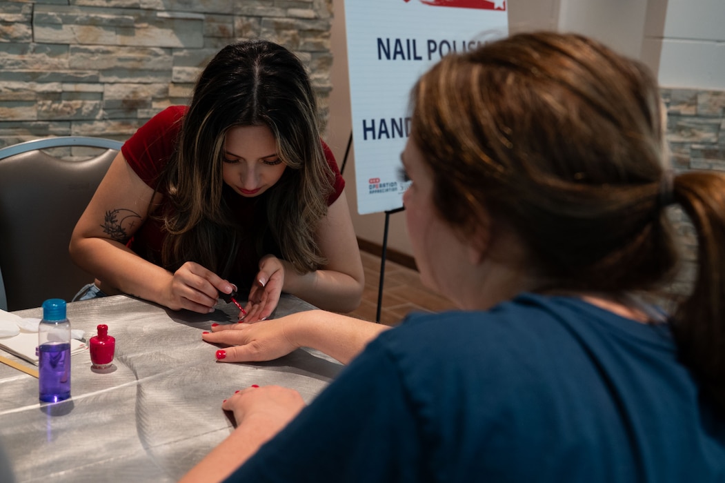 Avireece Obregon, Howard College cosmetology student, paints a participant’s nails during the Spouse Resiliency & Wellness Day at the Powell Event Center, Goodfellow Air Force Base, Texas, May 9, 2025. Nail painting and hand massages were offered as a self-care activity for spouses. (U.S. Air Force photo by Airman 1st Class Brian Lummus)