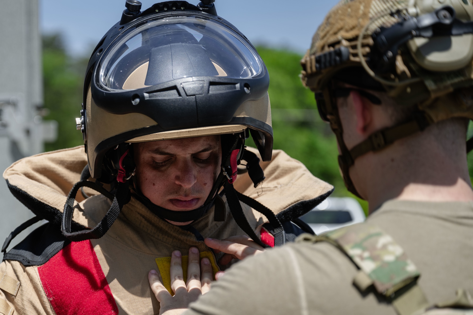 Staff Sgt. Zachary Flessner gets help putting a bomb suit during a Combat Readiness Inspection.