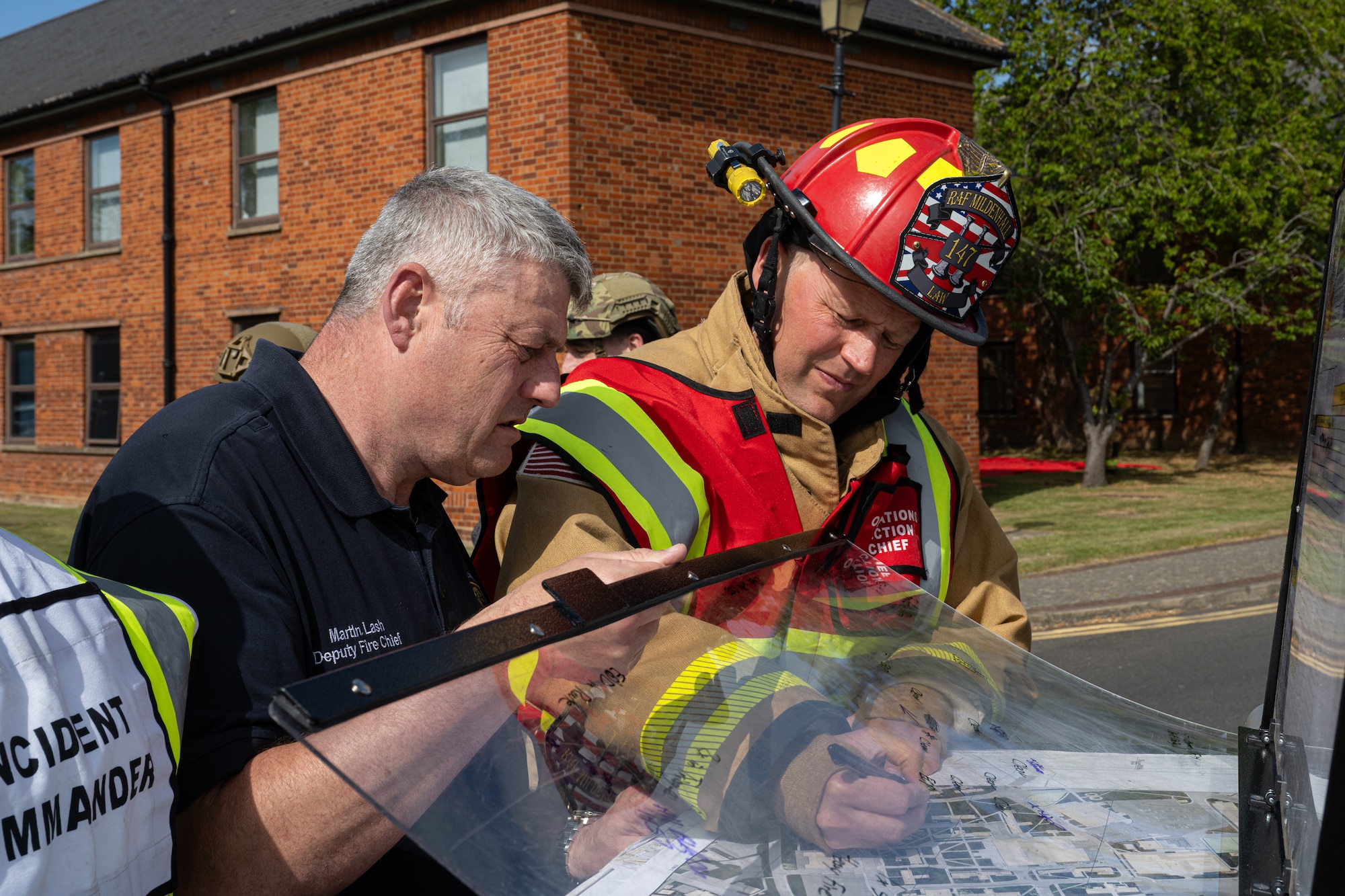 Firefighters assigned to the 100th Civil Engineer Squadron make annotations on a map following a simulated vehicle-borne improvised explosive device detonation during exercise Skyway Chariot at RAF Mildenhall, England, May 8, 2025.