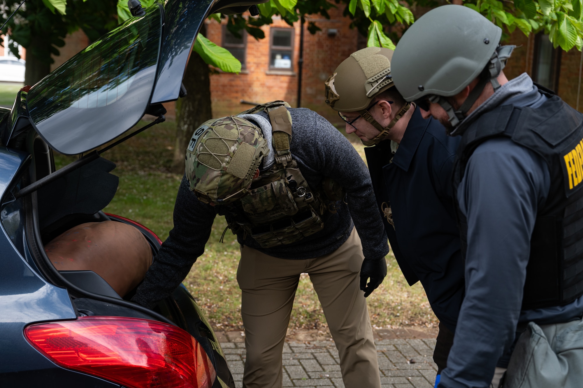 U.S. Airmen assigned to the 100th Security Forces Squadron and Air Force Office of Special Investigations inspect a simulated vehicle-borne improvised explosive device scene during the combat readiness inspection Skyway Chariot at RAF Mildenhall, England, May 8, 2025.