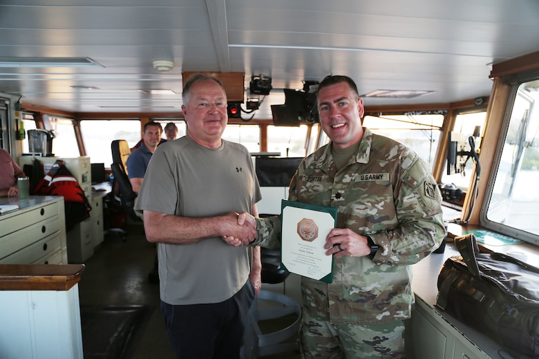 Lt. Col. Kenneth M. Porter, U.S. Army Corps of Engineers, Deputy District Commander of the Wilmington District presents a 15-year ength of service award to Victor S. Nelson, USACE Dredge MURDEN master captain from the dredge Murden on April 24, 2025, in Guantanamo Bay, Cuba. The MURDEN is clearing critical shoaling by dredging areas that will maintain safe and efficient navigation conditions for military and commercial vessels in the harbor. (USACE Photo by Mark Rankin)