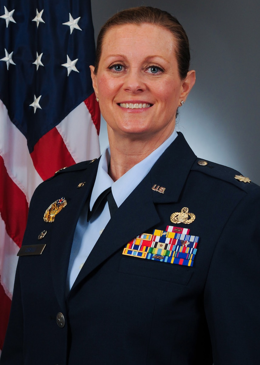 A smiling Airman poses for a photo in blues.
