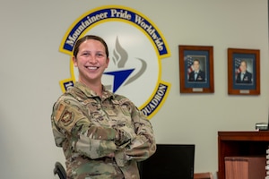 a women in uniform stands with her arms crossed  over her chest