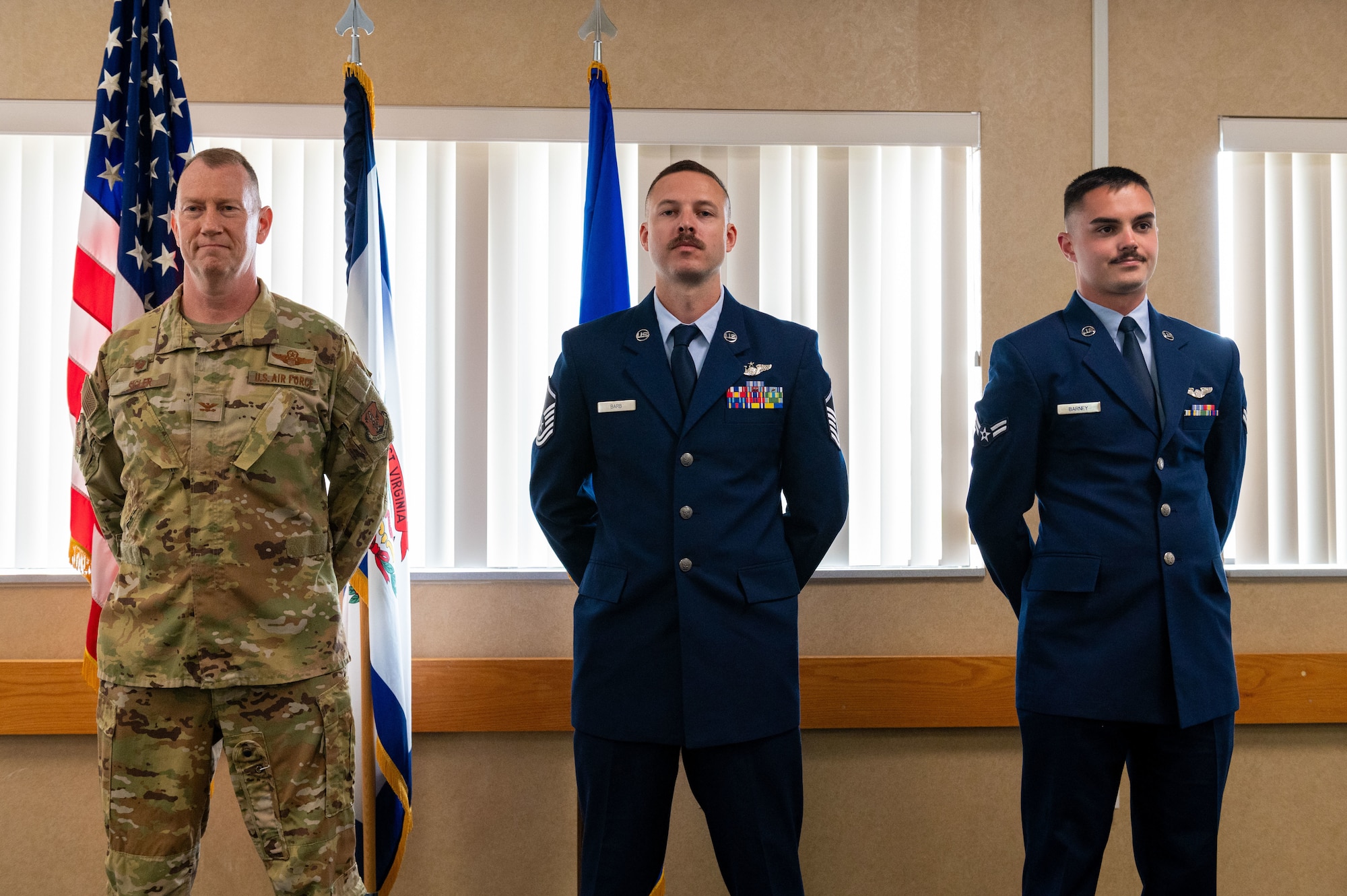 three men in uniform stand in a row