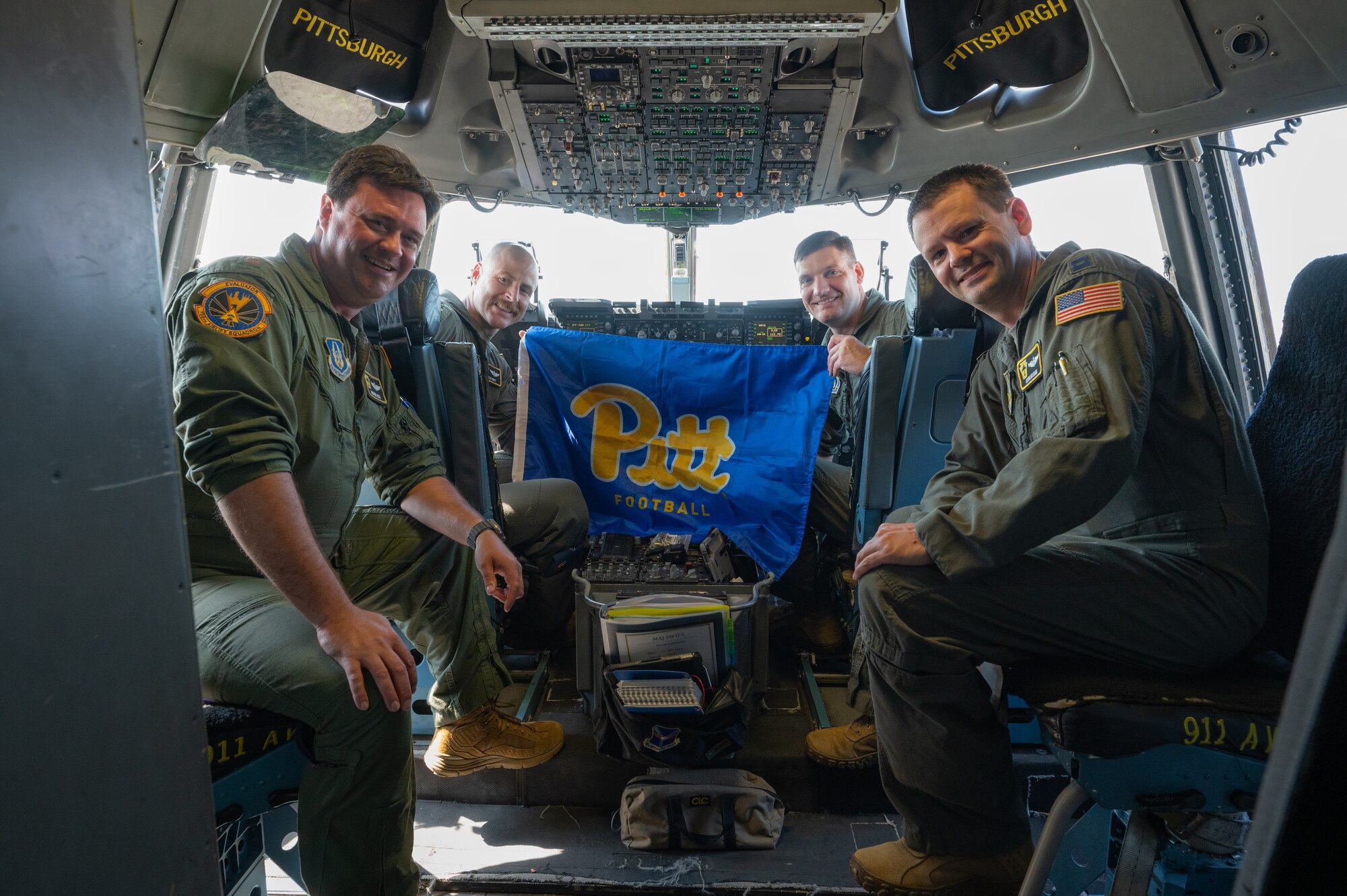 Air Force Pilots hold a Pitt University flag in a C-17 Globemaster III