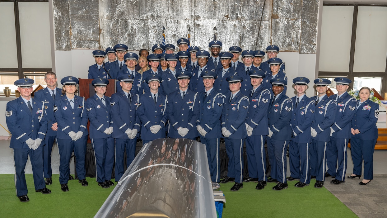 A large group photo of honor guard members in military service dress