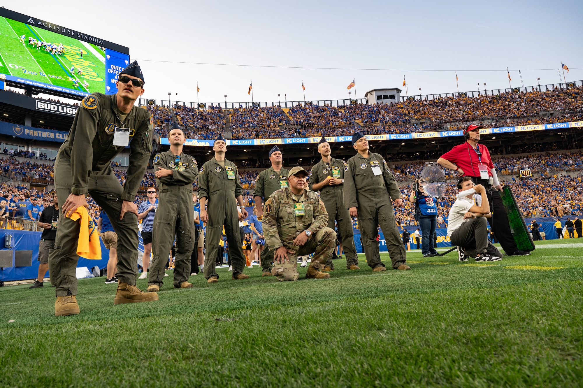 airman watch a football game from the field at Acrisure Stadium