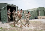 Practical Nursing students rush to respond to a simulated mass casualty event during a field training exercise at Joint Base San Antonio – Camp Bullis, Texas, April 25, 2025. The FTX, hosted by BAMC’s Department of Hospital Education and Training, was held at Camp Bullis’s Deployable Medical Systems Equipment Training site, which recreates genuine deployment conditions, complete with the exact equipment, layout, and operational constraints students will likely encounter in real-world missions. (DoD photo by Jason W. Edwards)