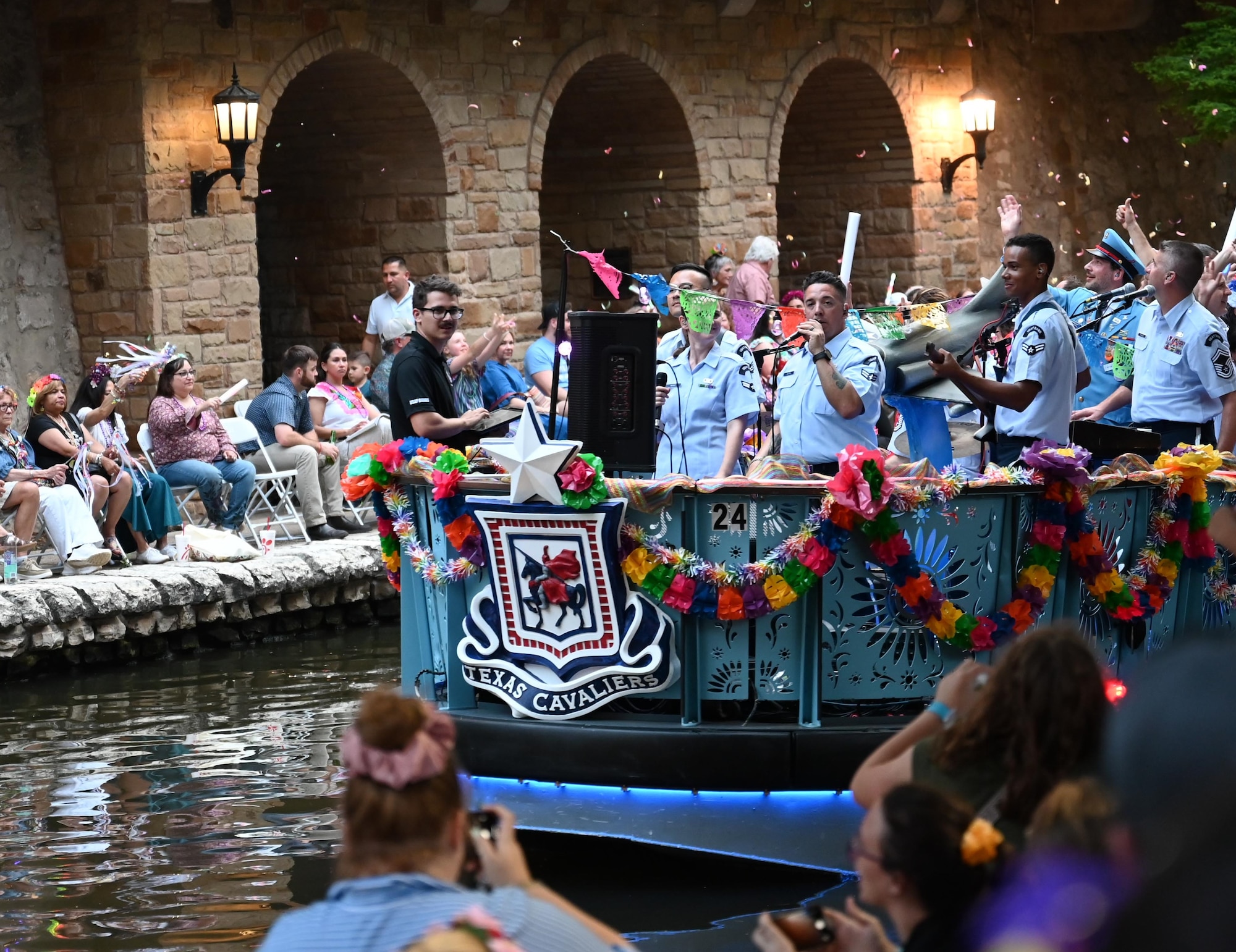 An Air Force boat floats by in a parade with Airmen playing music.