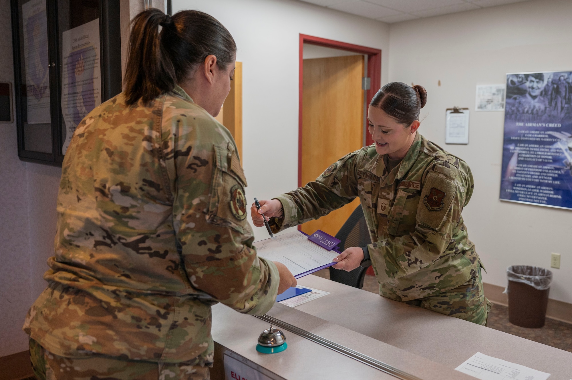Master Sgt. Jordan Reynolds, 28th Operational Medical Readiness Squadron aerospace medicine flight chief, reviews paperwork with Tech. Sgt. Sarah Lowry, 28th OMRS bioenvironmental engineer flight chief, at Grand Forks Air Force Base, N.D., May 8, 2025. The integration of 28th Medical Group personnel into the 319th Medical Group to support B-1B Lancer operations has tested Grand Forks AFB's ability to accept and support an additional flying mission for an ejection seat platform. (U.S. Air Force photo by Airman 1st Class Emma Funderburk)