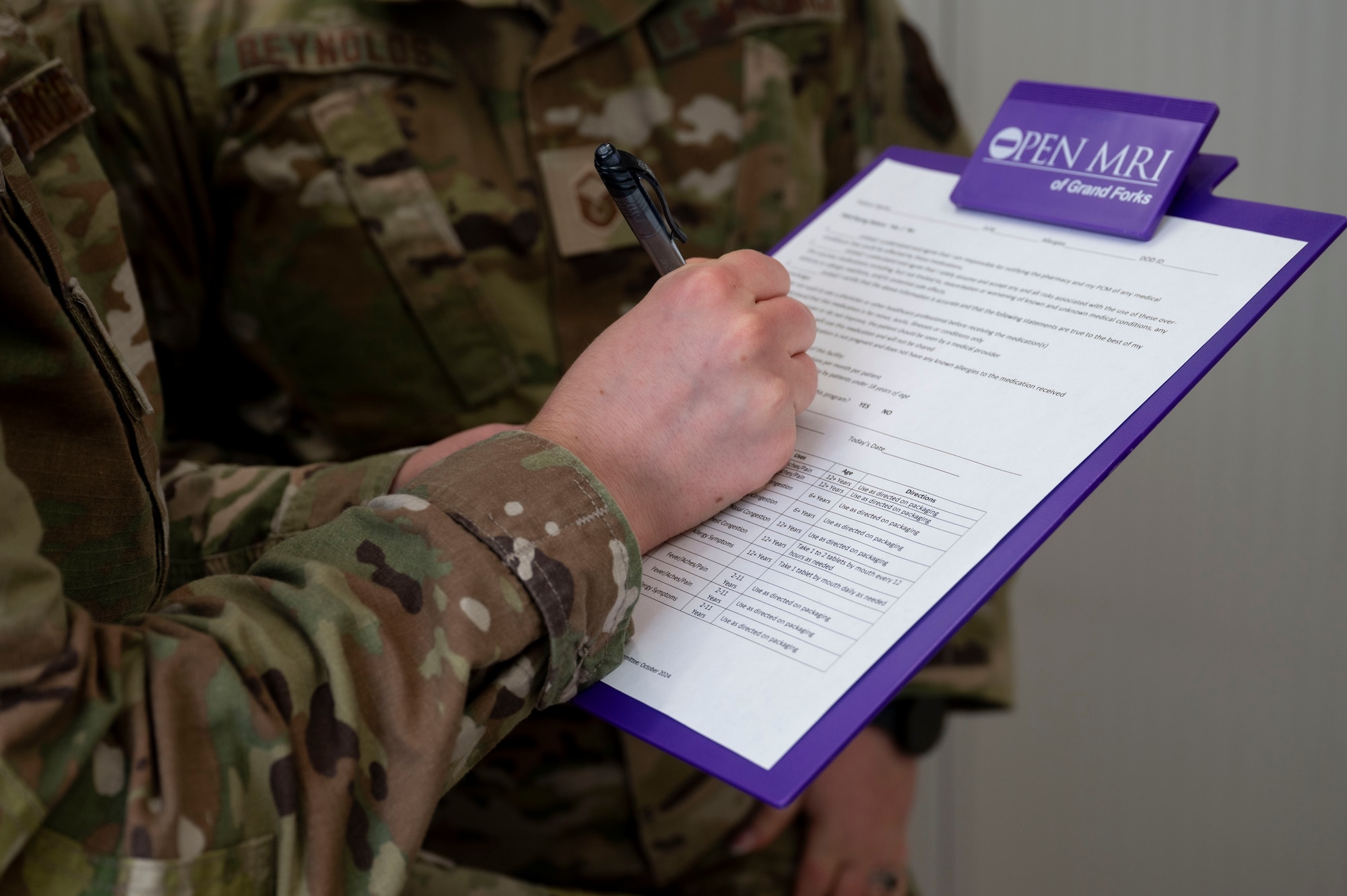 Master Sgt. Jordan Reynolds, 28th Operational Medical Readiness Squadron aerospace medicine flight chief, helps an airman assigned to the 28th Bomb Wing fill out paperwork at Grand Forks Air Force Base, N.D., May 6, 2025. To minimize the 319th Medical Group mission impact of approximately 800 additional personnel on station, the 28th BW sent medical staff to Grand Forks AFB to care for TDY personnel. (U.S. Air Force photo by Airman 1st Class Emma Funderburk)