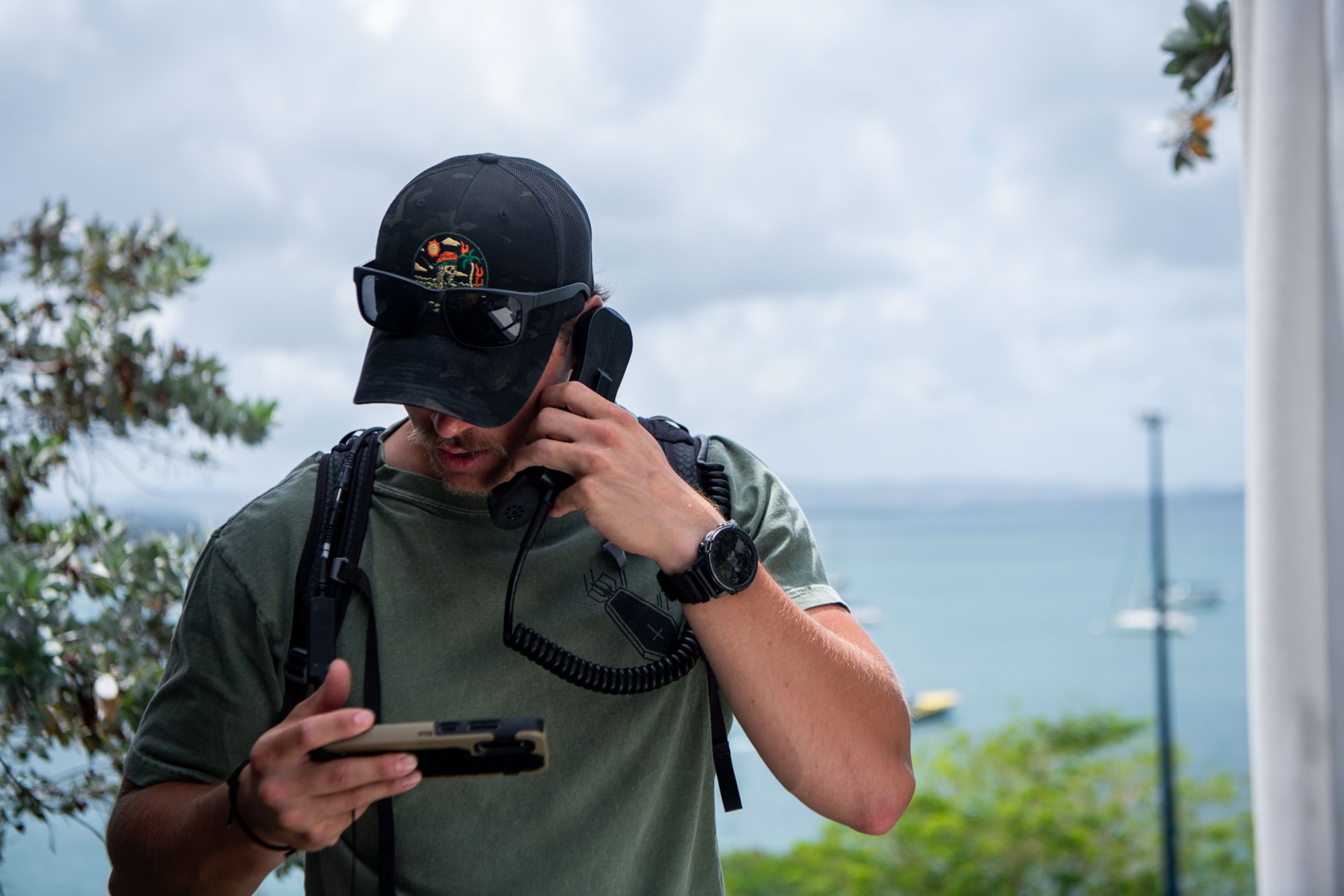 A man answers a radio call while looking down.