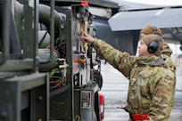 An airman performs maintenance on a B-1 bomber aircraft
