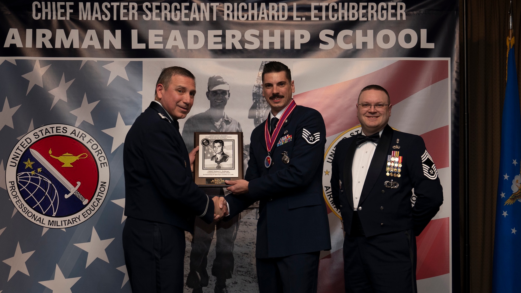 Col. Reynaldo Champion, commander of the 319th Mission Support Group and Chief Master Sgt. Aaron Smith, 319th Medical Group Senior Enlisted Leader present Staff Sgt. Steven A. Todd, assigned to the 319th Security Forces Squadron with the Commandant’s Leadership Award at Grand Forks Air Force Base, N.D., May 8, 2025. (U.S. Air Force photo by Airman Nailah Pacheco)