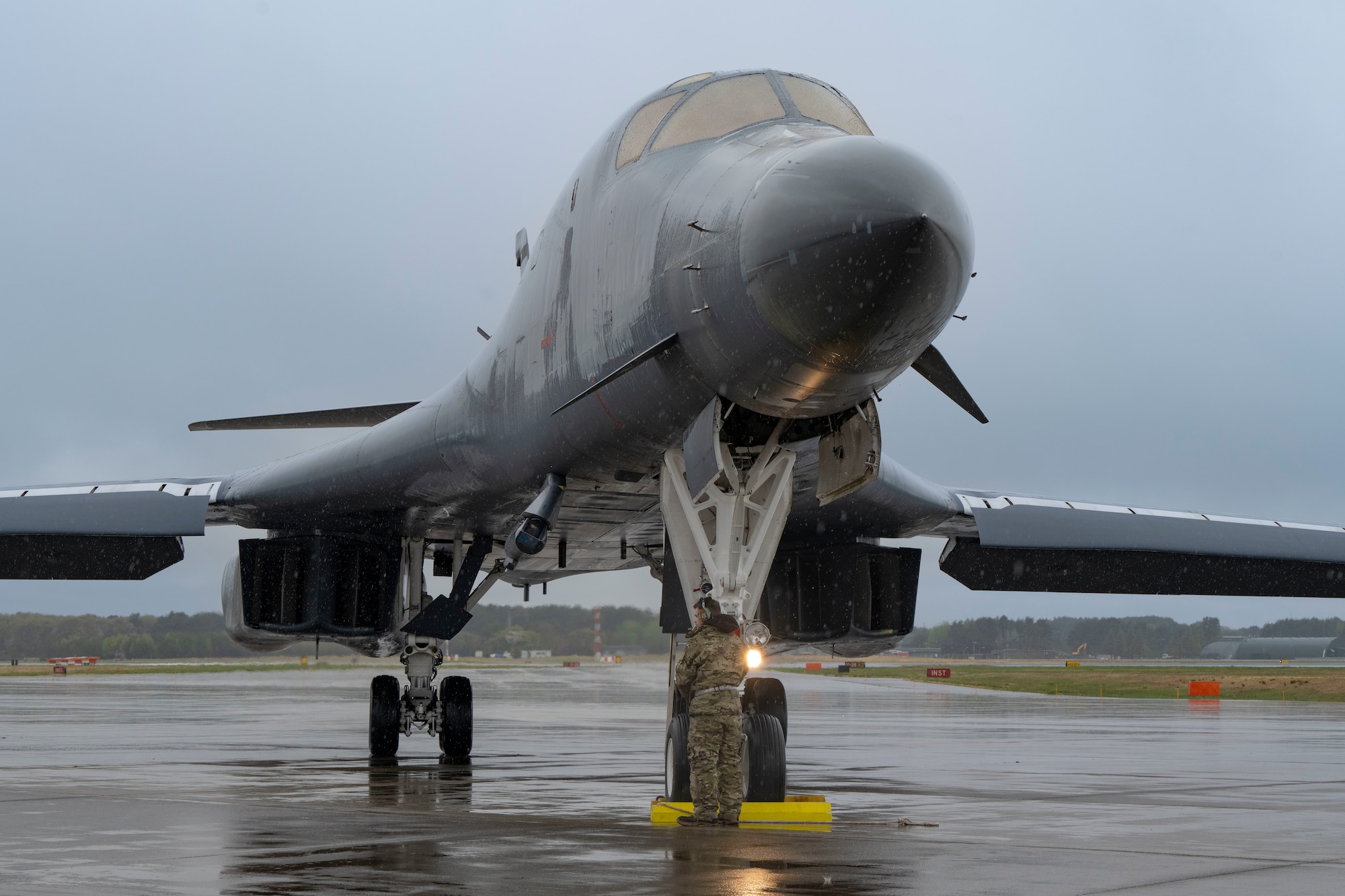 A B-1 bomber sits on the flightline in the rain