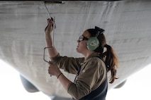 An airman performs maintenance on a B-1 bomber aircraft