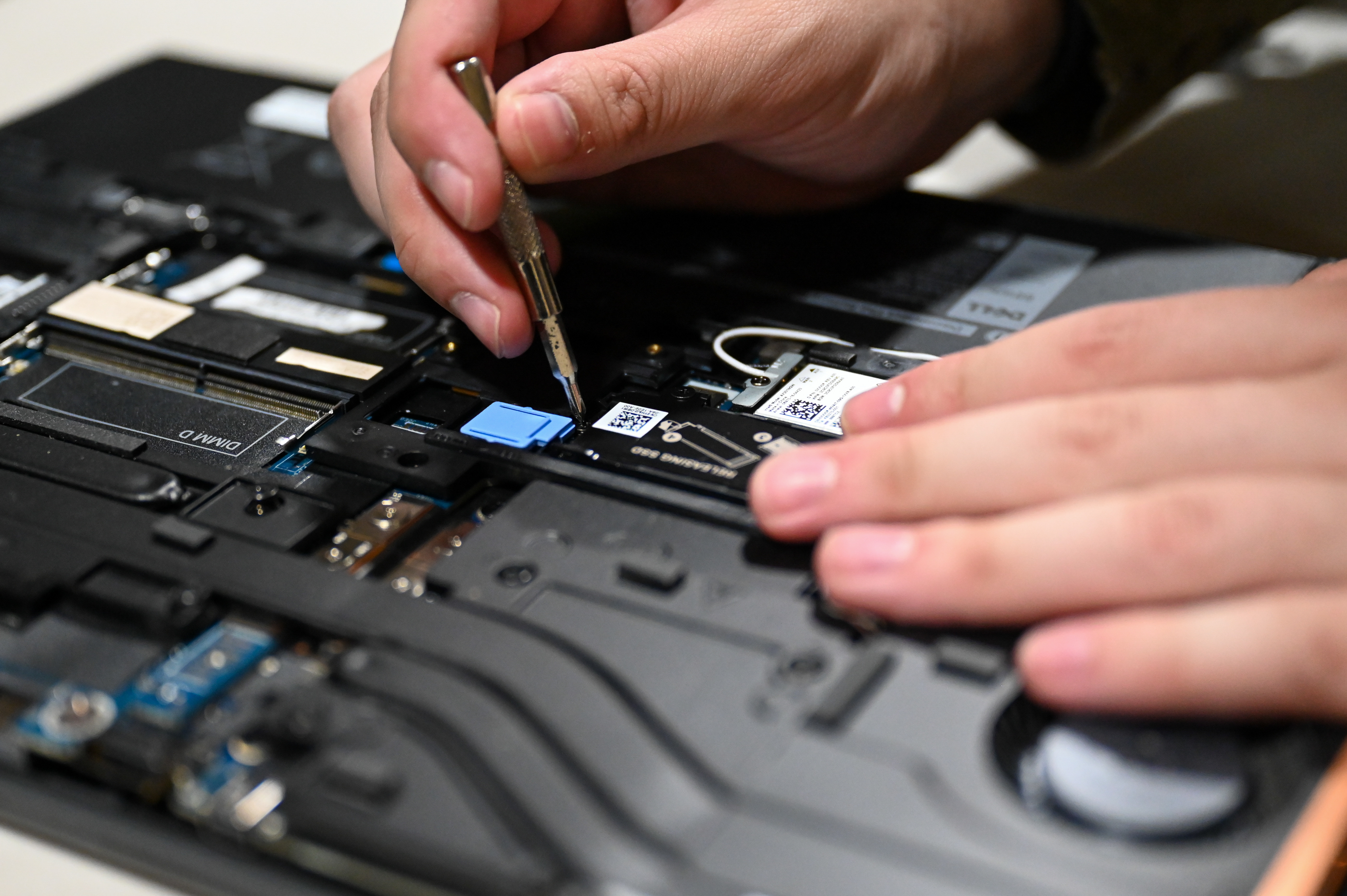 U.S. Air Force Senior Airman Daniel Bernier, 633d Communications Squadron asset management technician, opens a computer to remove the solid-state drive on Joint Base Langley-Eustis, Virginia, April 24, 2025. 633d CS can image more than 30 laptops per day allowing technology assets to be received, stored, and distributed quickly. (U.S. Air Force photo by Airman 1st Class Gerald Ligeralde)
