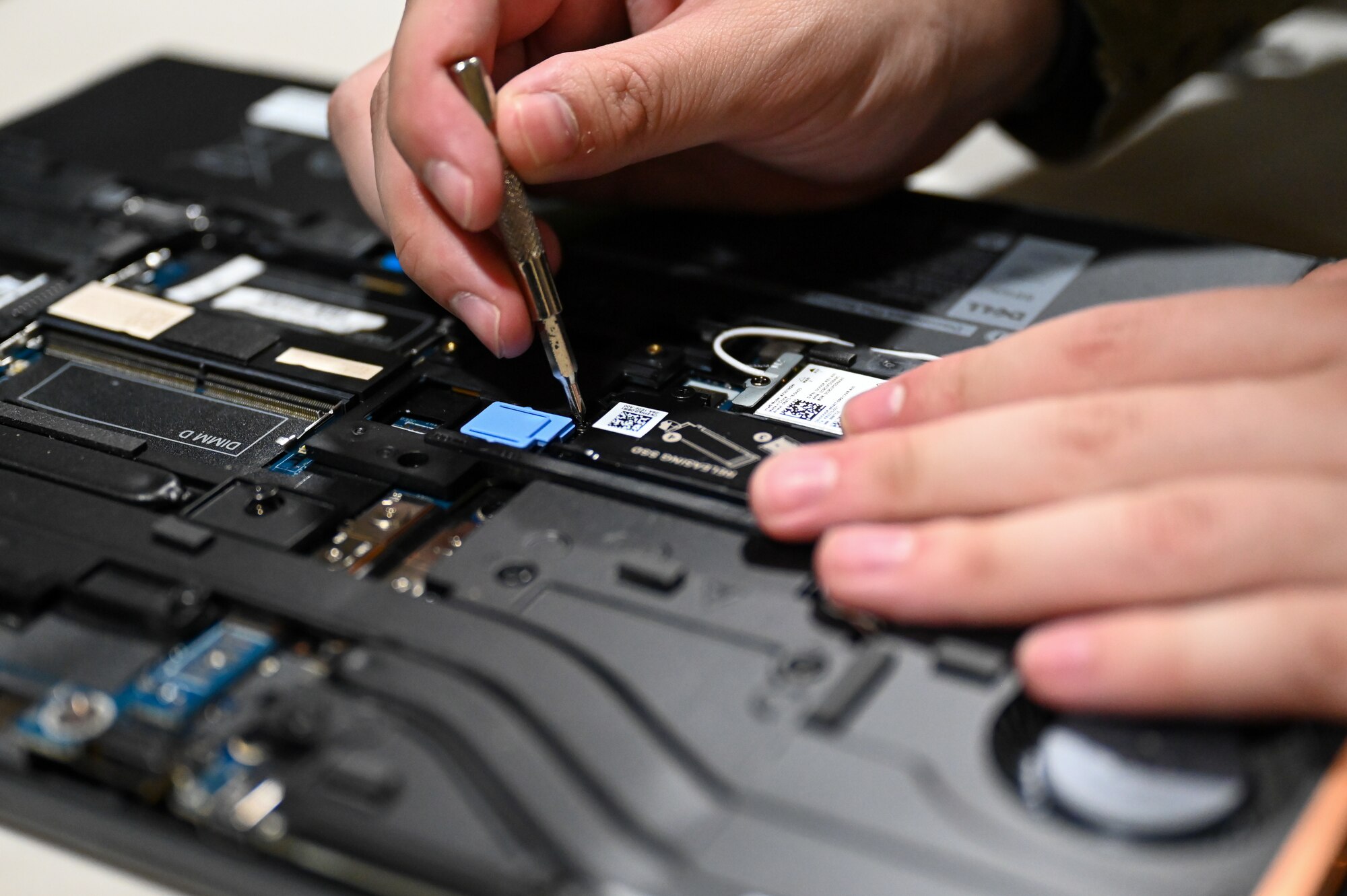 U.S. Airmen opens a computer and removes components within